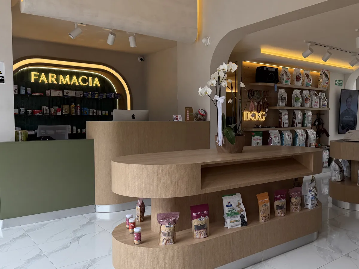 Farmacia veterinaria de MÜVA con su letrero iluminado, mostrador verde salvia y exhibidores de madera